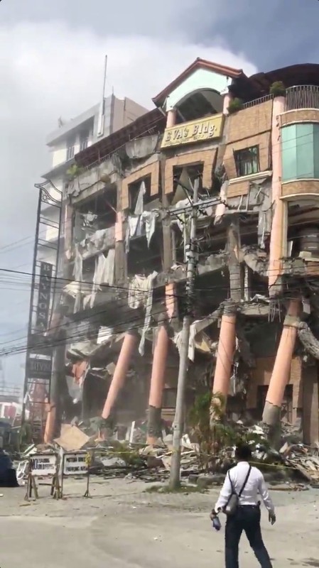 Social media video grab shows a man looking at a damaged hotel building after an earthquake in Kidapawan City