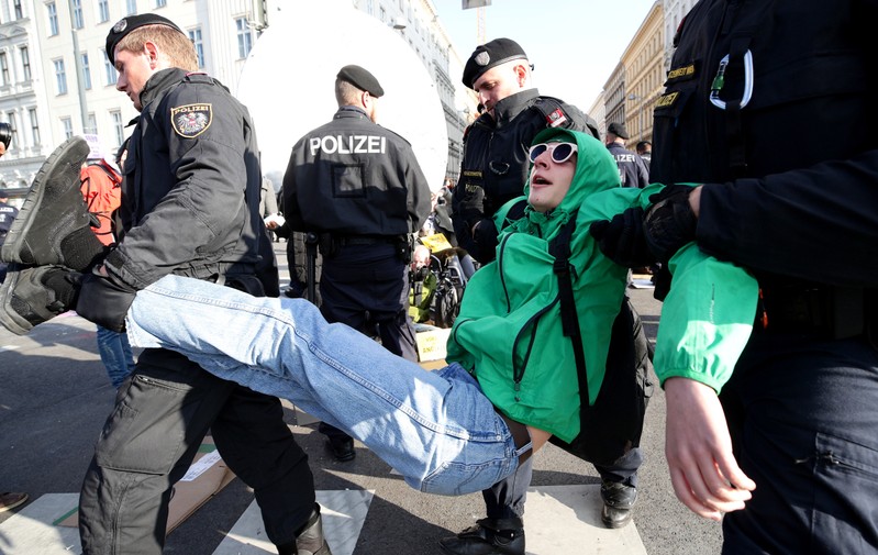 Police officers pull out a climate change activist as activists block a road during the Extinction Rebellion protest in Vienna