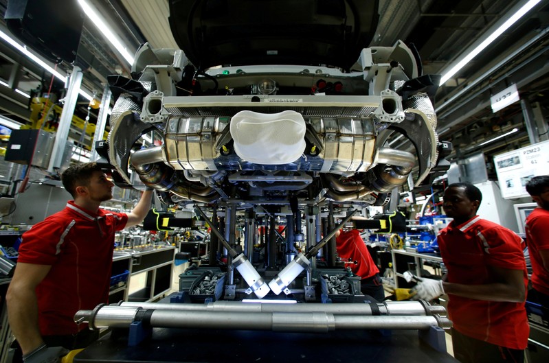 FILE PHOTO: Employees of German car manufacturer Porsche work on a sports car at the Porsche factory in Stuttgart-Zuffenhausen