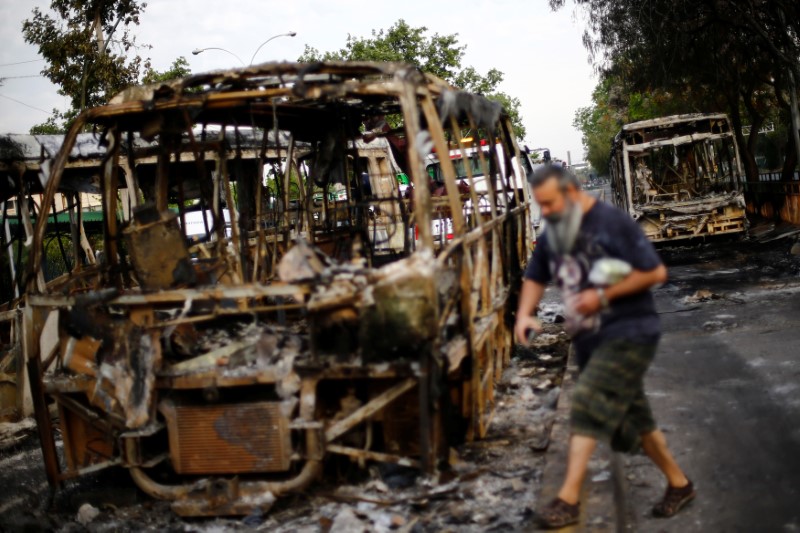 Burned busses are pictured after protest against the increase in subway ticket prices in Santiago
