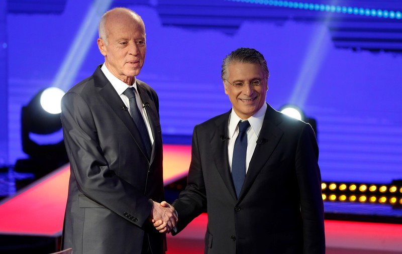 Tunisian presidential candidates Nabil Karoui and Kais Saied shake hands before a televised debate ahead of Sunday's second-round runoff election in Tunis