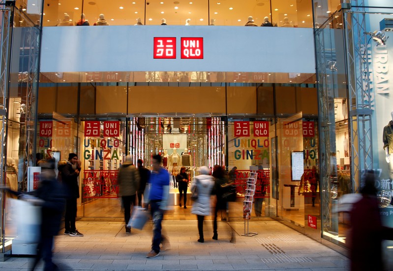 FILE PHOTO: People walk past Japan's Fast Retailing Co Ltd's Uniqlo signboard at its shop in Tokyo