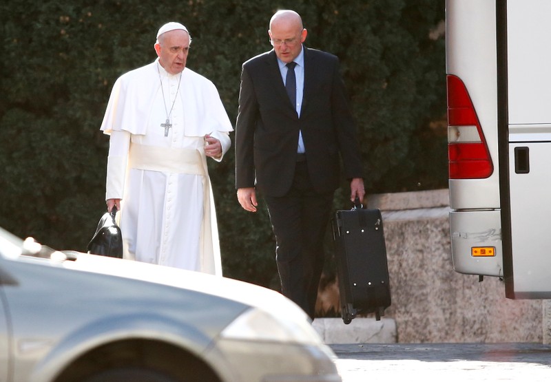 FILE PHOTO: Pope Francis walks next to Inspector General of the Corpo della Gendarmeria Giani before boarding a bus heading to Ariccia from the Vatican