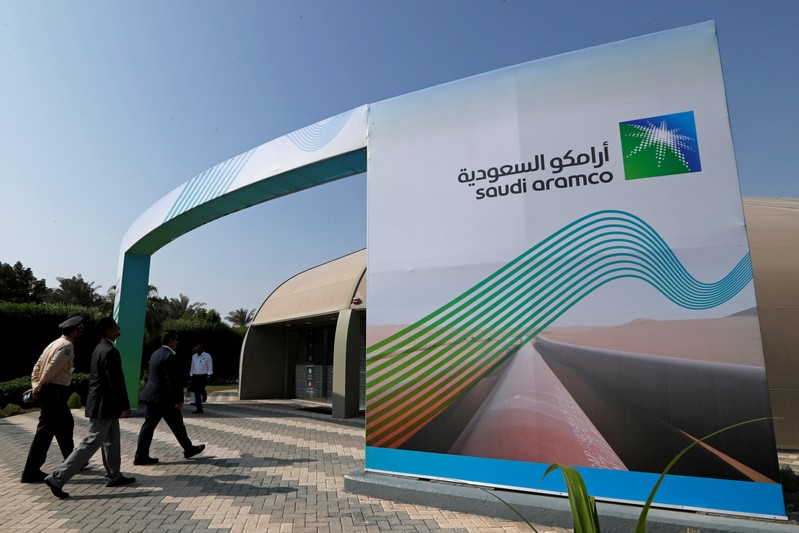 FILE PHOTO: Logo of Aramco is seen as security personnel walk before the start of a press conference by Aramco at the Plaza Conference Center in Dhahran