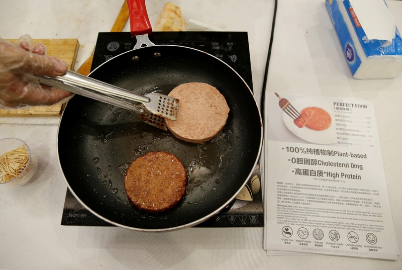 Cook makes Whole Perfect Food plant-based patties at VeggieWorld fair in Beijing