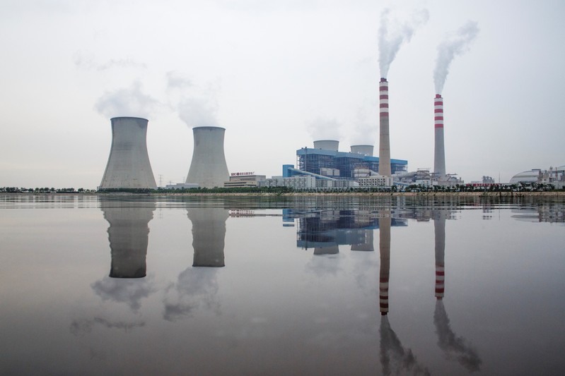 A power station of the State Development & Investment Corporation (SDIC) is reflected in a lake in Tangshan