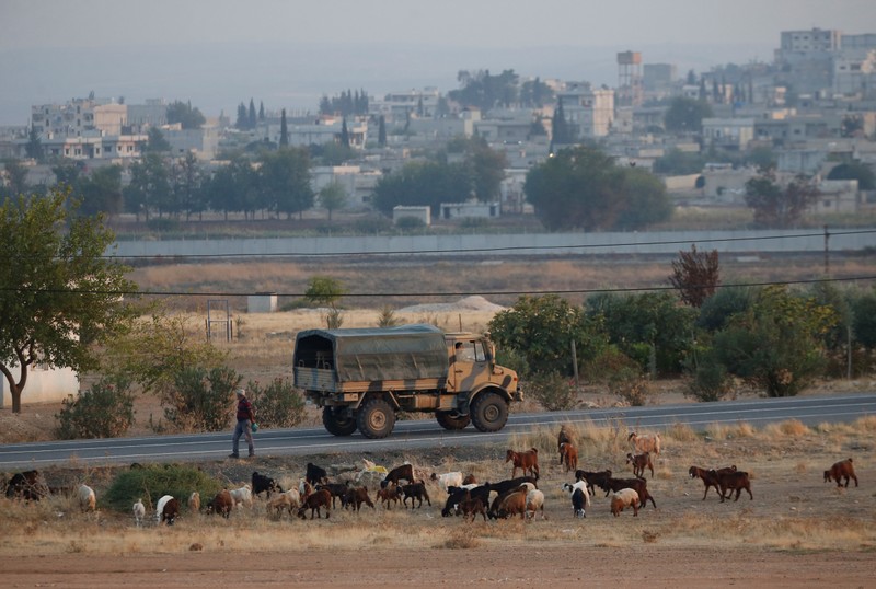 FILE PHOTO - A Turkish military truck drives on the Turkish-Syrian border, with the Syrian town of Kobani in the background, in Suruc