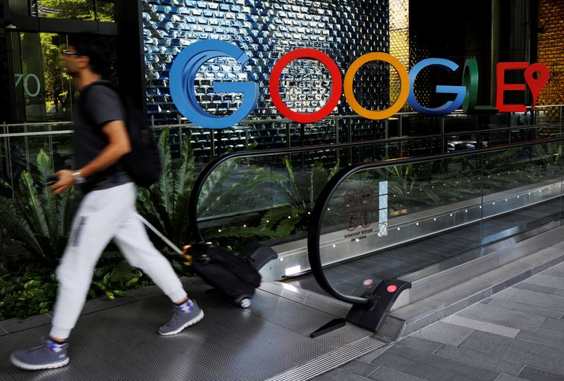 FILE PHOTO: A man passes a Google signage outside their office in Singapore