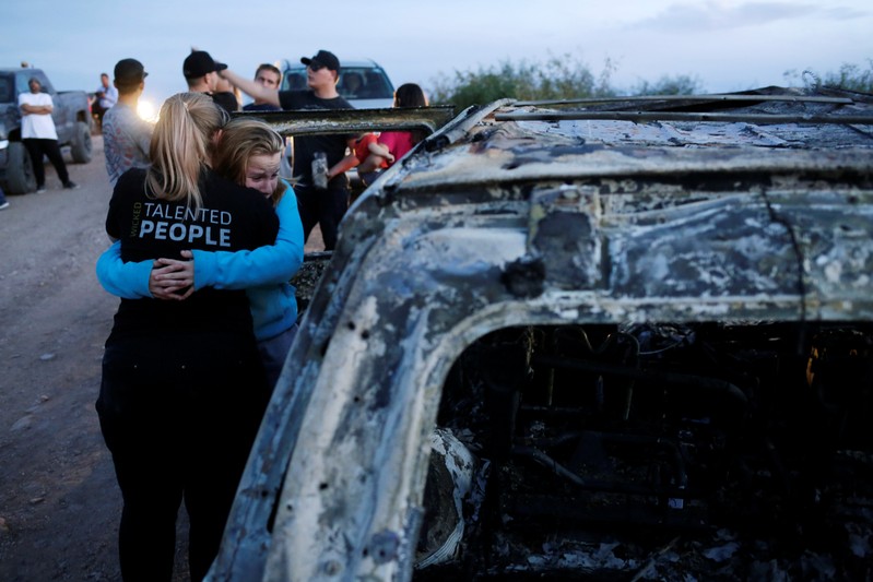 Relatives of slain members of Mexican-American families belonging to Mormon communities react next to the burnt wreckage of a vehicle where some of their relatives died, in Bavispe