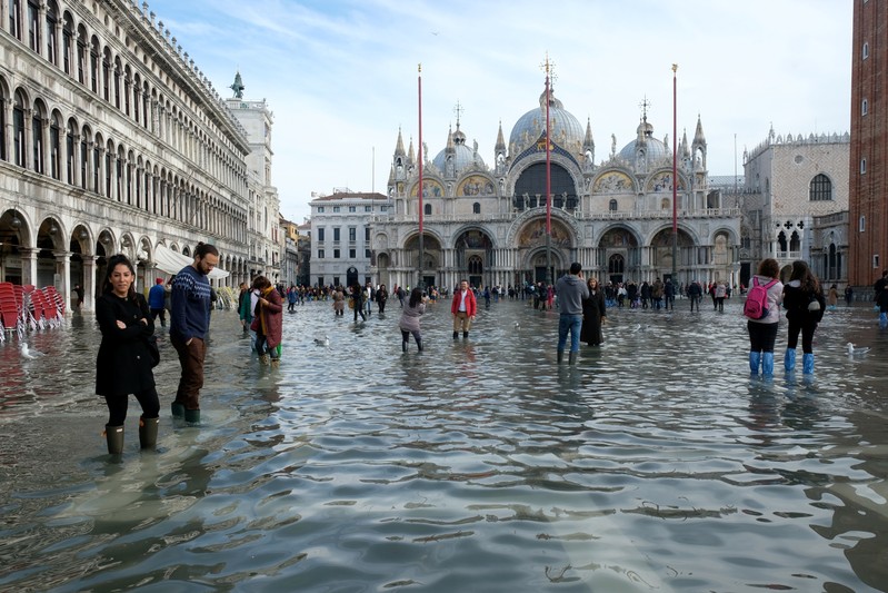 Tourists walk in St. Mark’s Square after days of severe flooding in Venice