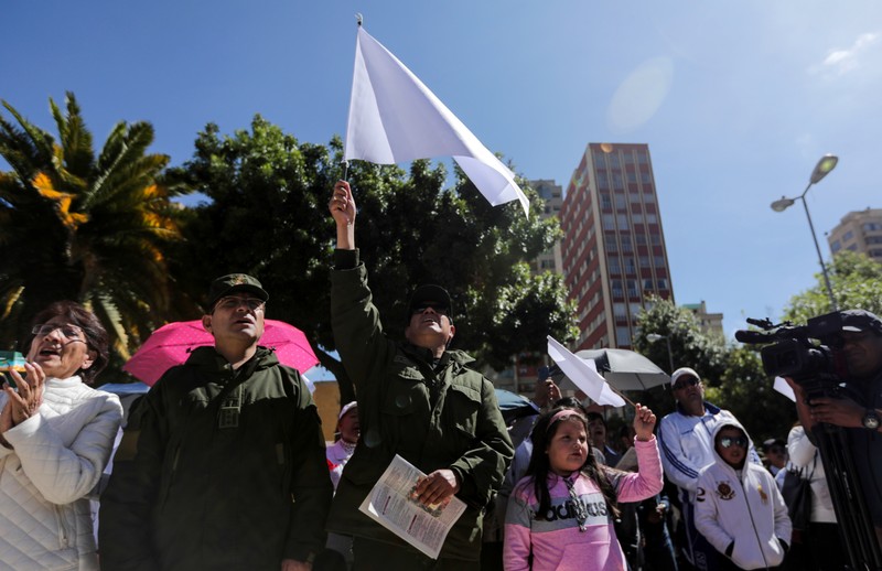 Bolivian people and police officers participate in a Mass offered in intention of peace in the country, in La Paz