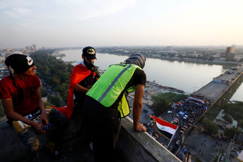 FILE PHOTO: Iraqi demonstrators are seen on the top of the building called by Iraqis 'the Turkish Restaurant Building', during anti-government protests in Baghdad
