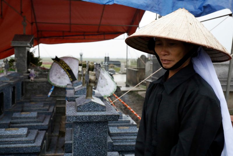 Nguyen Thi Huan visits the newly built grave of her son Nguyen Dinh Luong, a victim who was found dead in the back of British truck, at the homeland cemetery in Ha Tinh province
