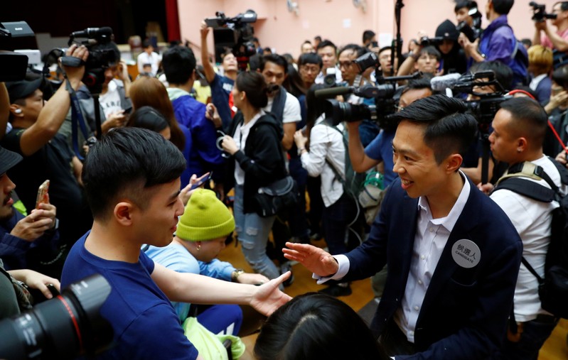 Local candidate Kelvin Lam celebrates with supporters at a polling station in the South Horizons West district in Hong Kong