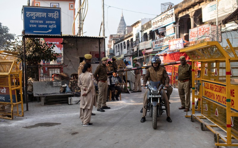 Police officers stand guard at a security barricade near a temple after Supreme Court's verdict on a disputed religious site, in Ayodhya