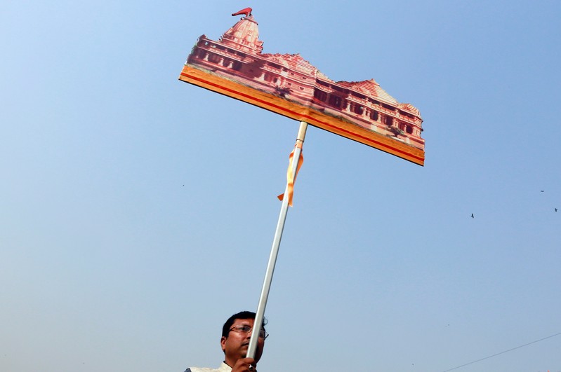 A supporter of the Vishva Hindu Parishad (VHP), a Hindu nationalist organisation, carries a cutout of a proposed Ram temple that Hindu groups want to build at a disputed religious site in Ayodhya, during 
