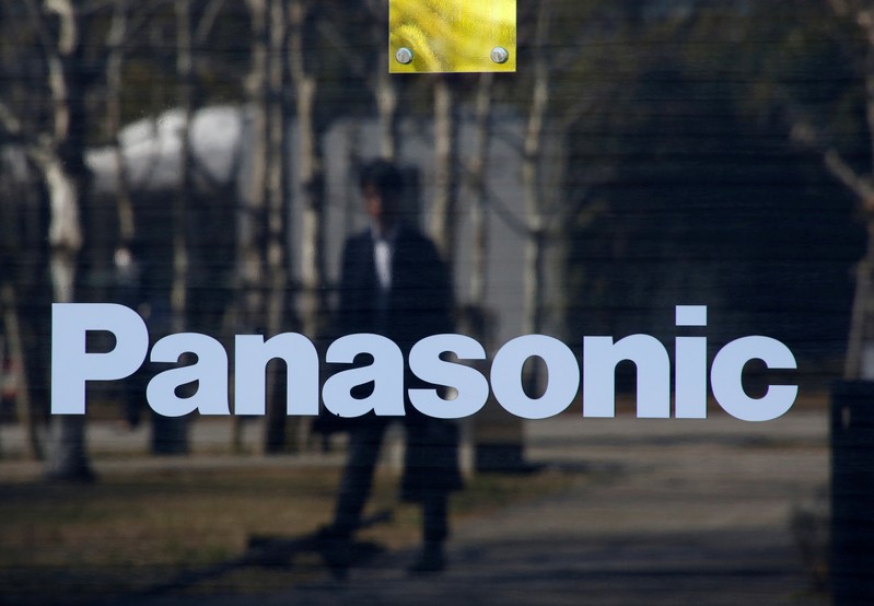 FILE PHOTO: A man is reflected on Panasonic Corp's logo at Panasonic Center in Tokyo