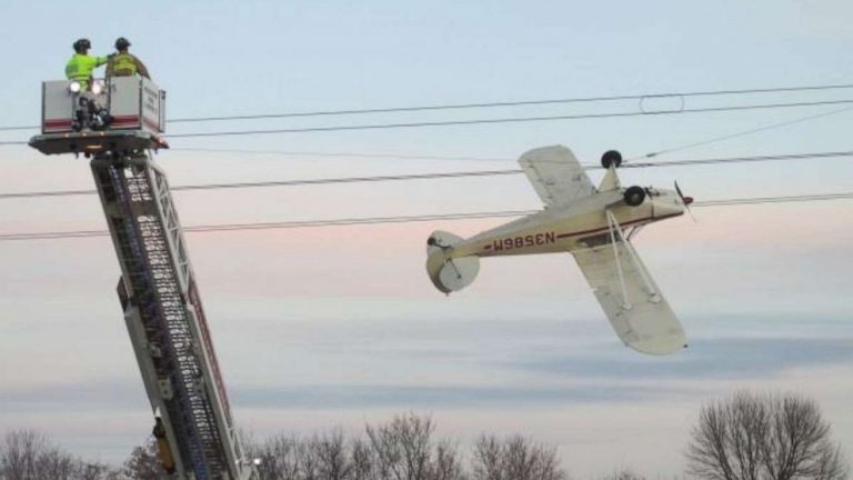 Pilot rescued after small plane becomes entangled upside down in power line
