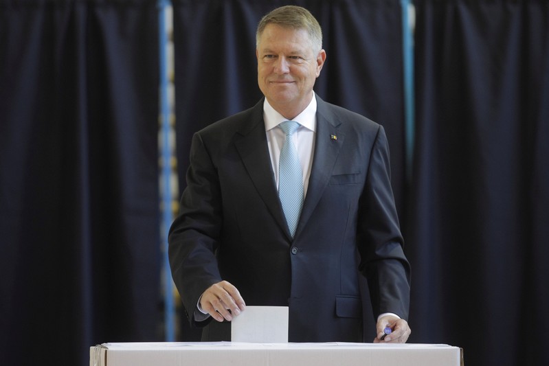 Incumbent candidate Klaus Iohannis smiles as he casts his ballot in the first round of a presidential election