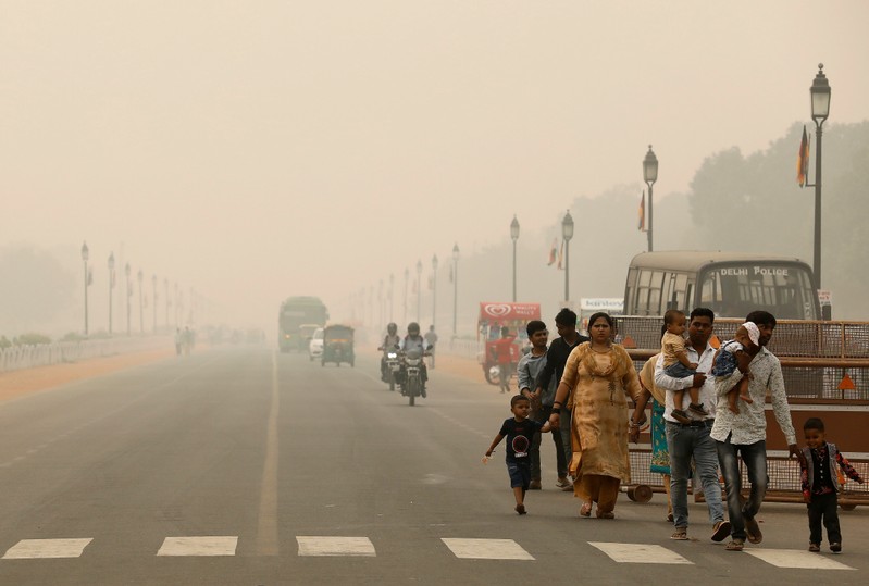 People walk on the Rajpath on a smoggy day in New Delhi