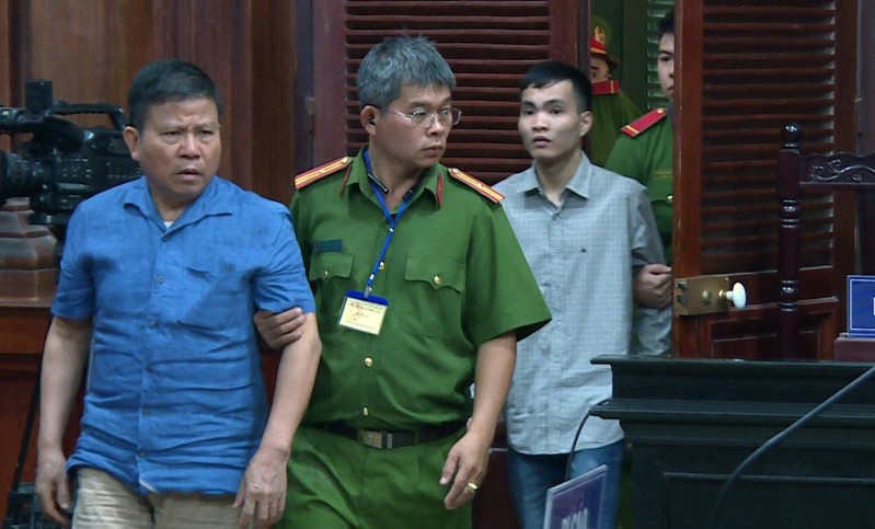 FILE PHOTO: Police escort Chau Van Kham and Tran Van Quyen to their trial at a court in Ho Chi Minh city