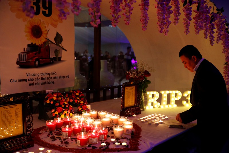 A man lights a candle at a make shift memorial at a fundraising event organised by Britain's Vietnamese community to raise money for the families of the 39 people found inside a container, at a conference venue near Wolverhampton, Britain