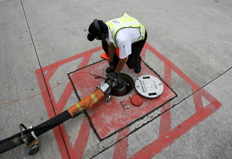 File photo of a technician attaching a jet fuel supply pipe to outlet in tarmac at Changi airport in Singapore