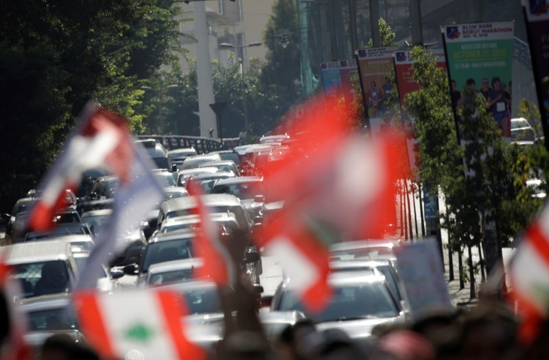 Demonstrators carry national flags during anti-government protests in Beirut