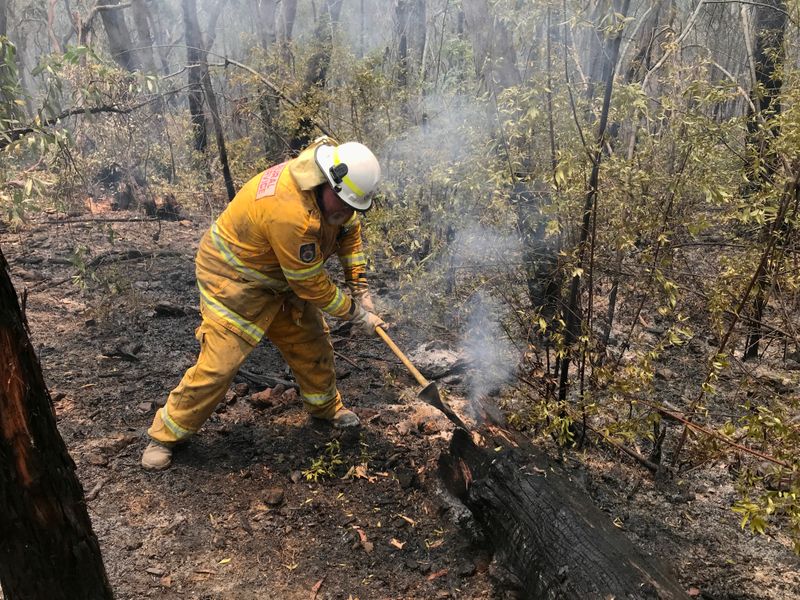 A volunteer from the New South Wales Rural Fire Service works to extinguish spot fires following back burning operations in Australia’s Blue Mountains