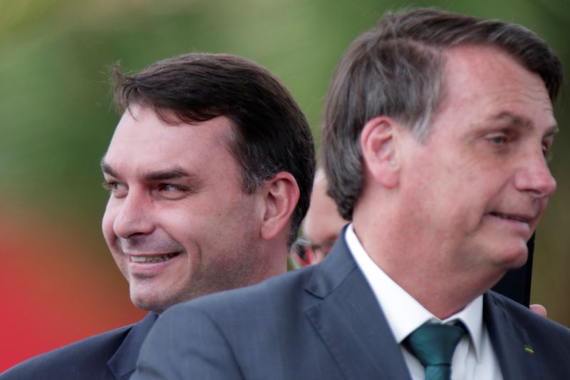 FILE PHOTO: Brazil’s Senator Flavio Bolsonaro smiles near Brazil's President Jair Bolsonaro after the launch of a new political party, the Alliance for Brazil (APB) in Brasilia