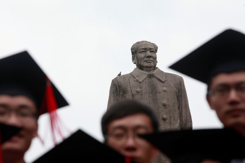 FILE PHOTO: Graduates pose for picture in front of statue of late Chinese leader Mao after graduation ceremony at Fudan University in Shanghai