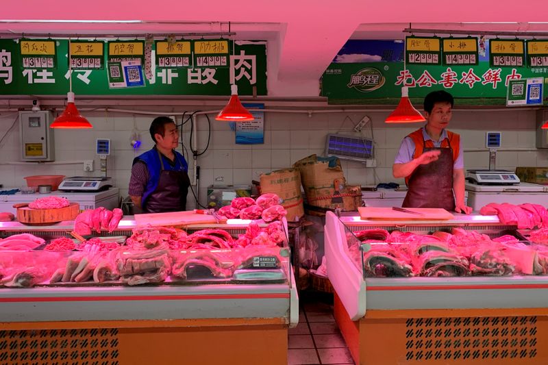 FILE PHOTO: Pork vendors at a market in Beijing