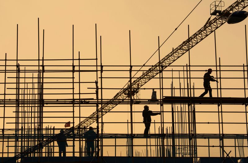 Workers are seen on scaffolding at a construction site in Nantong