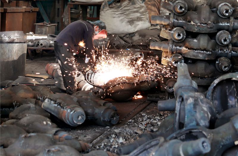 Worker welds automobile parts at a workshop manufacturing automobile accessories in Huaibei, Anhui