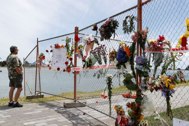 A man looks at a memorial at the harbour in Whakatane, following the White Island volcano eruption in New Zealand