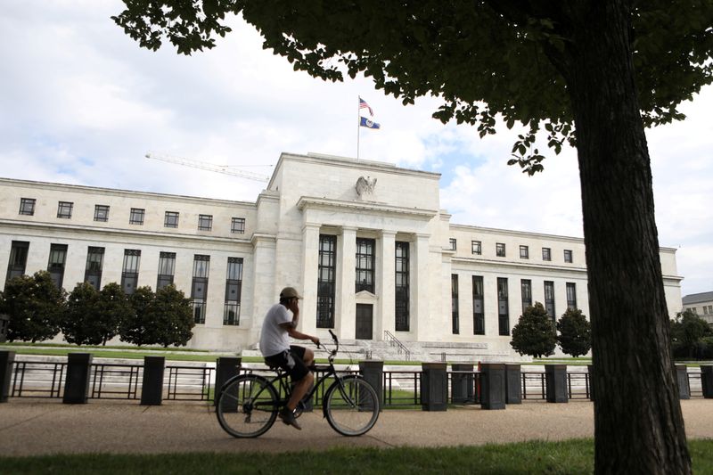 FILE PHOTO: A cyclist passes the Federal Reserve building in Washington, DC