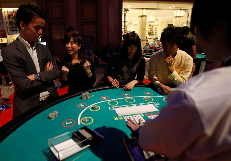 FILE PHOTO: Visitors react after they win a mock baccarat casino game at an international tourism promotion symposium in Tokyo
