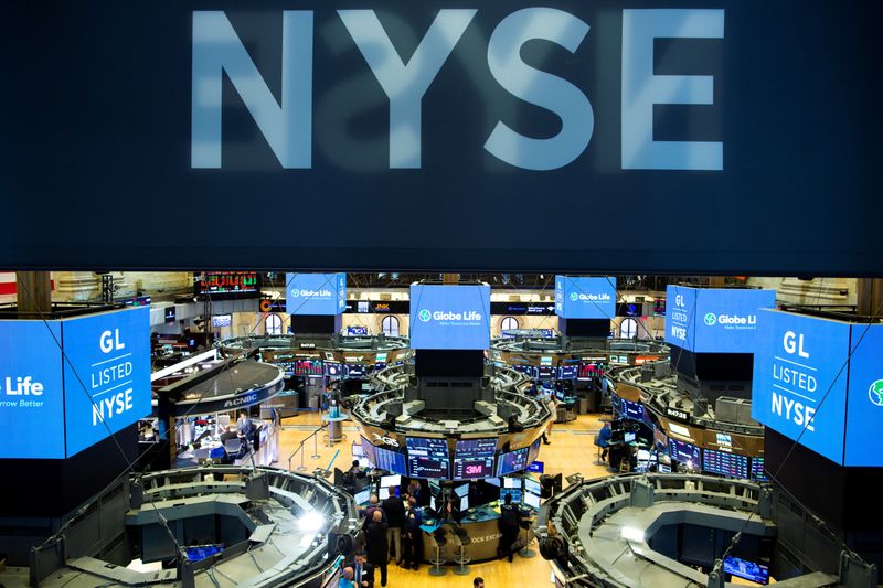 FILE PHOTO: Traders work on the floor at the New York Stock Exchange (NYSE) in New York