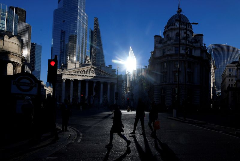 FILE PHOTO: Workers cross the road in the City of London, near the Royal Exchange and Bank of England