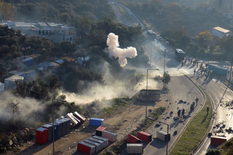 Smoke from tear gas canisters rises next to a camp for refugees and migrants, during clashes between migrants and riot police, on the island of Samos