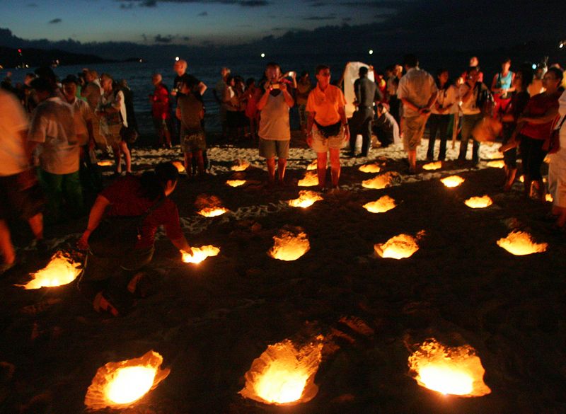 Families of tsunami victims light candles during a vigil on Patong beach in Phuket