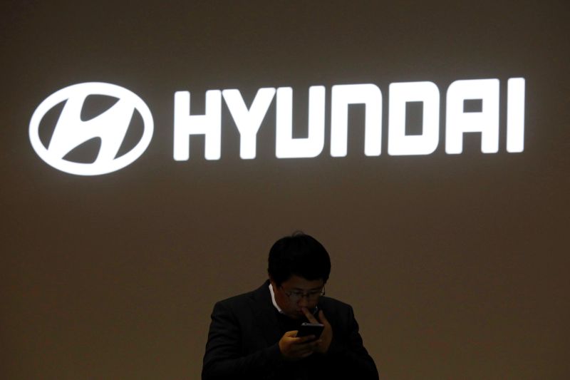 A man walks past the logo of Hyundai Motor during the 2019 Seoul Motor Show in Goyang