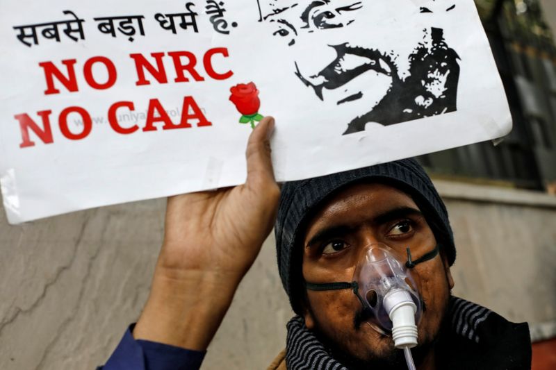 A demonstrator holds a placard during a protest against a new citizenship law, in New Delhi