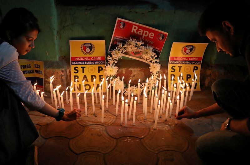 People light candles during a vigil as they attend a protest against the alleged rape and murder of a 27-year-old woman, in Kolkata