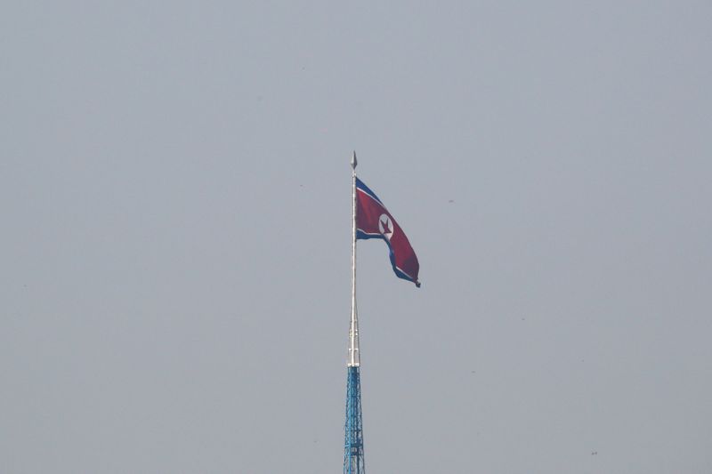 FILE PHOTO - A North Korean flag flutters on top of a tower at North Korea's propaganda village of Gijungdong, as seen from Paju