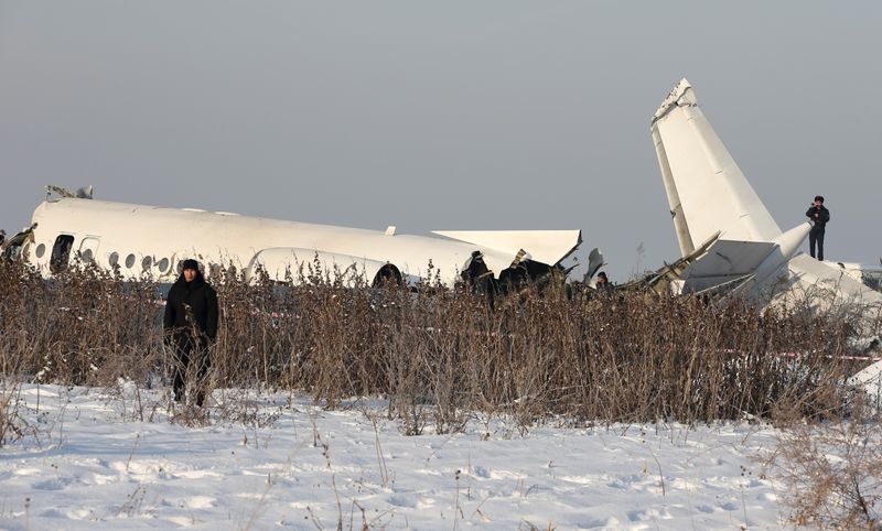 Emergency and security personnel are seen at the site of a plane crash near Almaty
