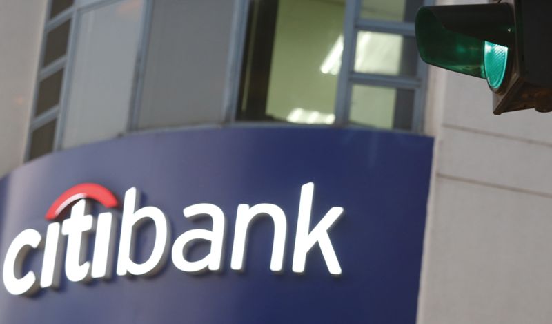 A green traffic light is pictured in front of a sign board of Citibank in Hanoi