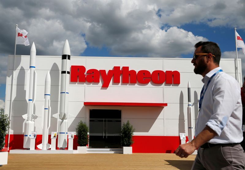 FILE PHOTO: A visitor walks past the Raytheon stand at the 53rd International Paris Air Show at Le Bourget Airport near Paris