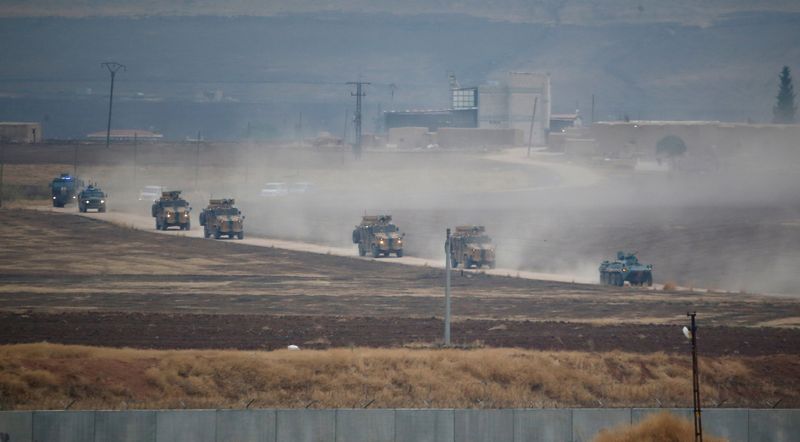 FILE PHOTO: Turkish and Russian military vehicles return following a joint patrol in northeast Syria, as they are pictured from near the Turkish border town of Kiziltepe