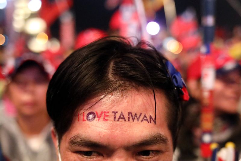 Supporters of Kuomintang party's presidential candidate Han react to his speech during an election rally in Taichung,